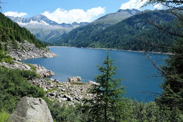 Fototapeta na wymiar paesaggio lago montagna natura acqua azzurro cielo cime rocce neve alberi verde 