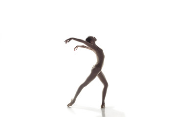 Young graceful female ballet dancer or classic ballerina dancing isolated on white studio. Caucasian model on pointe shoes
