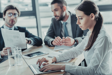 beautiful young businesswoman working with laptop during meeting at modern office