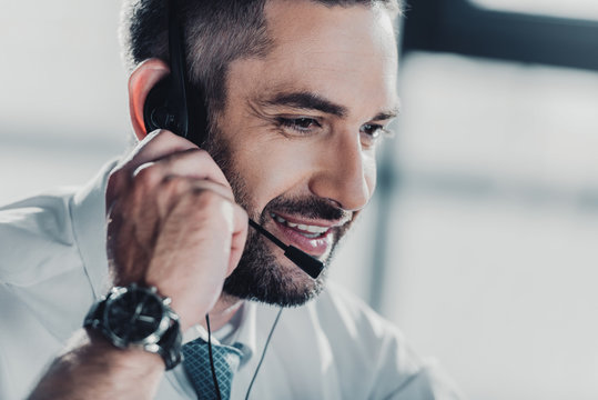 happy adult support hotline worker with microphone at work