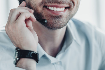 cropped shot of smiling support hotline worker holding microphone