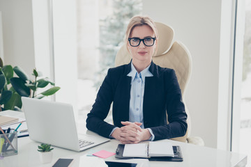 Portrait of charming pretty accountant in eyeglasses sitting in