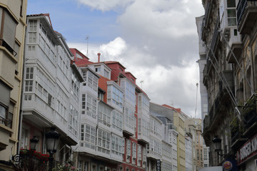Fototapeta na wymiar Typical Galician galerias, white enclosed balconies made of wood and glass, in the capital city La Coruña