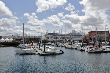 Fototapeta na wymiar The piers of La Coruña marina sea port with many sailing boats and a blue sky with some clouds