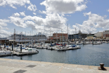 Fototapeta na wymiar The piers of La Coruña marina sea port with many sailing boats and a blue sky with some clouds