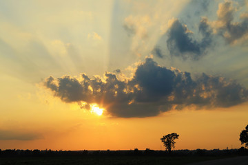 Obraz na płótnie Canvas Dramatic orange sky and rays at sunset