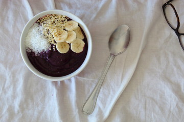 BlackBerry smoothie bowl with banana, coconut and almonds. Healthy breakfast in the bed.