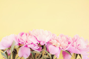 Bouquet of pink peonies on a cream background, top view, copy space