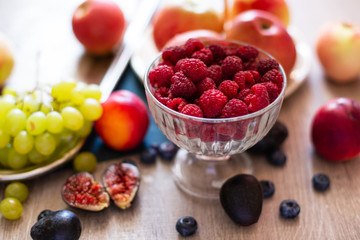 Assortment of Ripe Juicy Fruits on Wooden Table. Organic Raspberries,  Apples, Figs, Grapes - Summer dessert or Snack. Healthy Eating Concept.