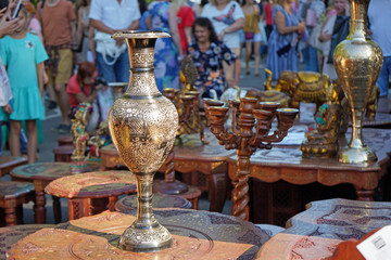 Gilded vase with Indian ornaments on a table made of mahogany.