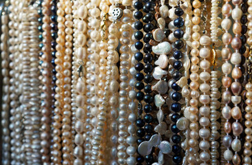 Long beads of natural river pearls in a street shop.