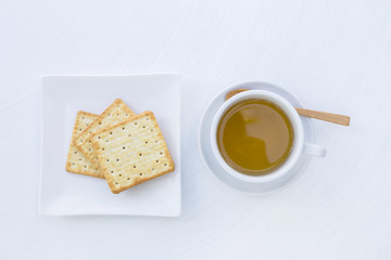 Hot tea and biscuit on white texture background, tea break time, light snack