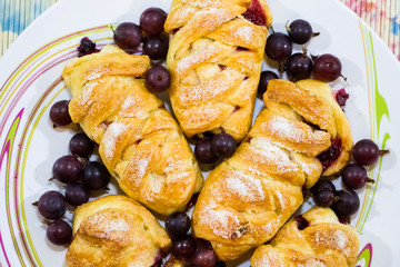 Buns from puff pastry stuffed with dark gooseberries