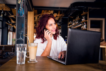Young student girl working with laptop at coffee shop
