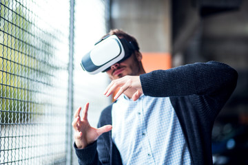 Handsome man using VR headset glasses of virtual reality