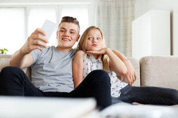 Siblings taking selife at home