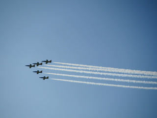 Reactive jet plane flying in formation and leave inversion trail on blue sky