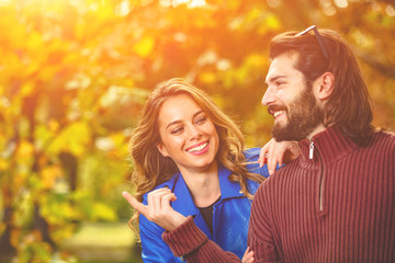 Fototapeta premium Couple in autumn season colored park enjoying outdoors.