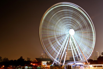 A great long exposure shot of a spinning illuminated Ferris wheel at night in Malaysia.