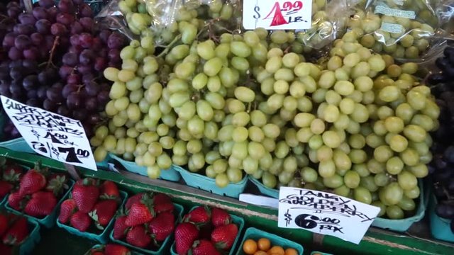 Man tastes grape from a counter