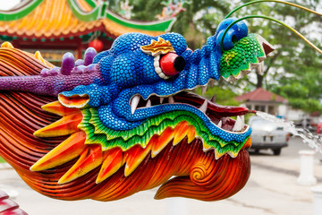 Obraz premium A nice close-up of a colourful water spraying dragon head at a Chinese temple. The water jet comes out of its tongue.