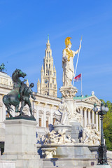 View of the fountain of Athena in front of the parliament building and the spire of the City Hall of Vienna, Austria. Tourist attractions