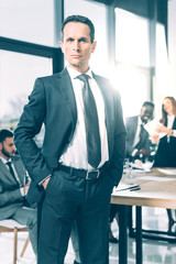 handsome businessman in suit with hands in pockets