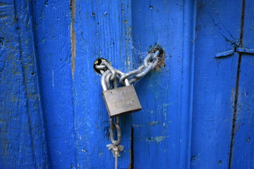 Puerta azul muy antigua con candado lleno de telara&ntilde;as