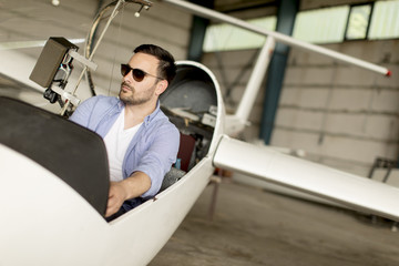 Young pilot checking ultralight airplane before flight