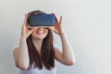 Smile young woman wearing using virtual reality VR glasses helmet headset on white background....