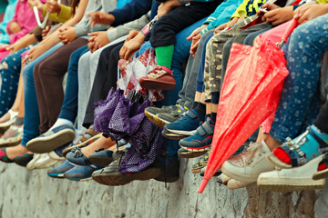 Children's feet. Bottom view. Spectators of a theatrical performance in the open air