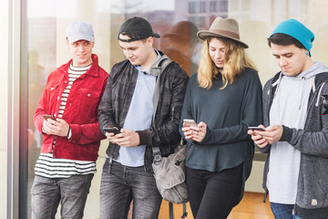 Group of friends watching smart mobile phones - Teenagers addiction to new technology trends - Concept of youth, tech, social and friendship - Main focus on center hands