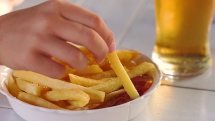 French fries with ketchup and a glass of beer