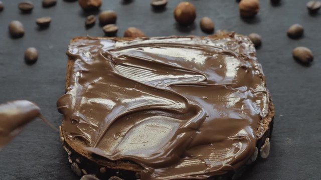 Spreading dark hot chocolate spread on bread