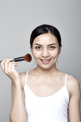 Woman applying cosmetic powder brush