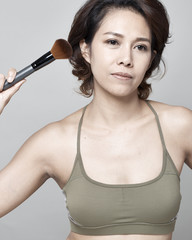 Woman applying cosmetic powder brush