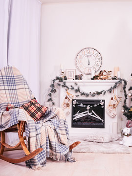 Xmas Fireplace with armchair, clocks and pillows. Christmas stocking over fireplace, New Year's card scenery. Snowman and stars. New Year concept.