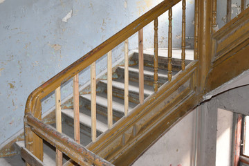 Stair case with wooden stairs and damaged walls in old slummy house. Location: Praga district of Warsaw city, Poland