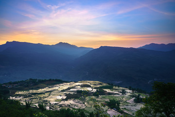 Terraced rice field in water season by sunset period, the time before starting grow rice in Y Ty, Lao Cai province, Vietnam