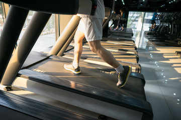 Obraz premium Machine treadmill with people running closeup at fitness gym