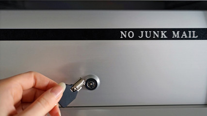 Female hand with a key. Young woman checking her mailbox for new letters.