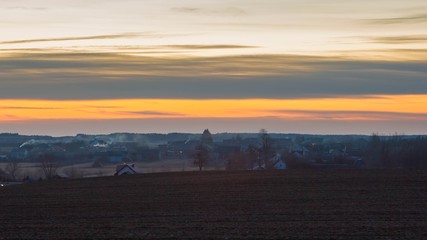 Fototapeta na wymiar Late evening sky over village near fields