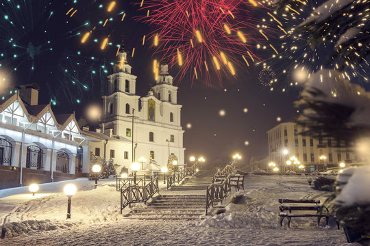 Minsk, Belarus. Festive fireworks in celebrate Christmas and New Year in Minsk. Landscape of Famous orthodox cathedral church at New year night, Belarus. Cityscape with Glowing lights and fireworks.