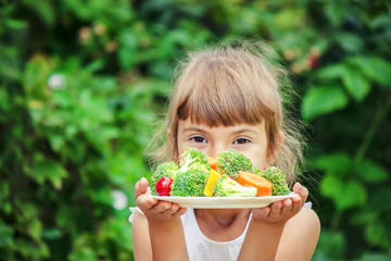 child eats vegetables. Summer photo. Selective focus.
