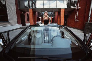 beautiful girl in a beautiful car cabriolet on the background of a beautiful building - obrazy, fototapety, plakaty