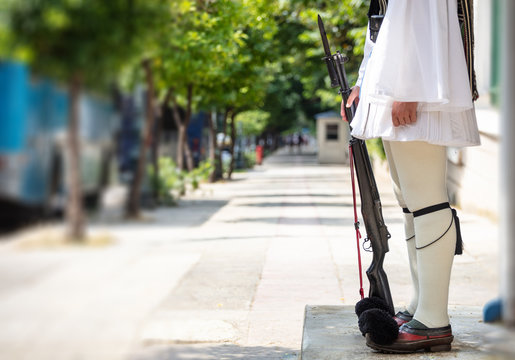 Athens, Greece. Tsolias is standing out of the outpost holding a rifle. Blur background.