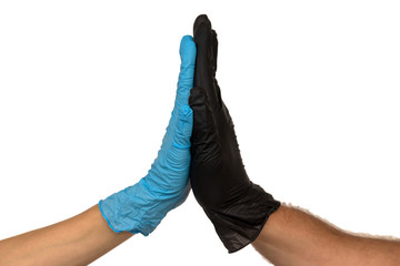 Man and a woman in multi-colored rubber gloves shake hands with each other. Isolate on a faded background. The concept of a successful team of medical interns