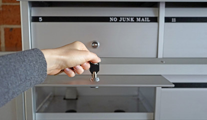 Female hand with keys, young woman opened her mailbox for new postage.