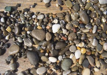 Wet colored stones lie on the beach