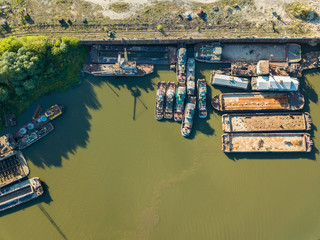 Fototapeta na wymiar Aerial drone view, old ships and barges are on the river on the pier.